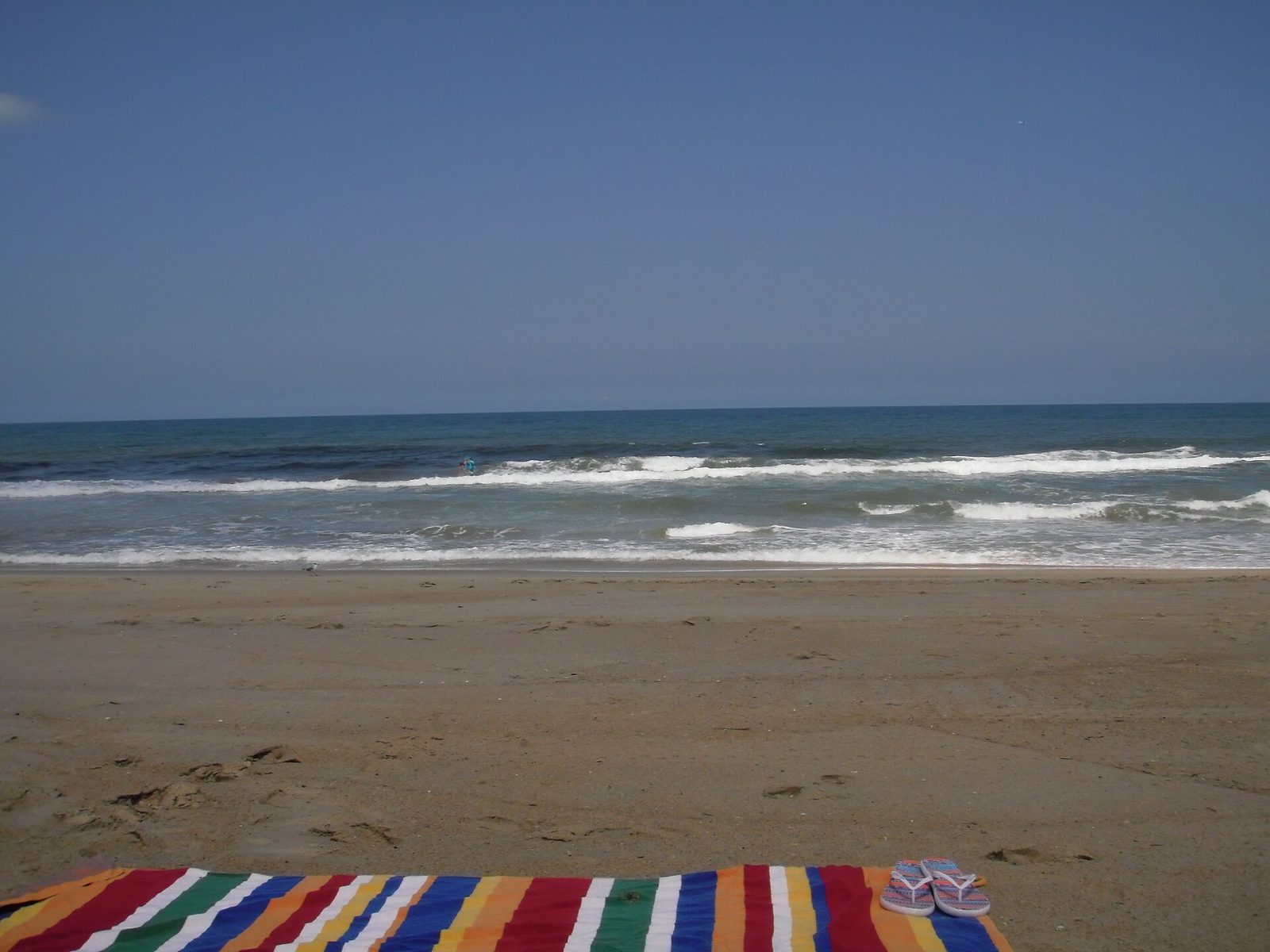 A quiet beach morning with a striped towel at Southern Shores